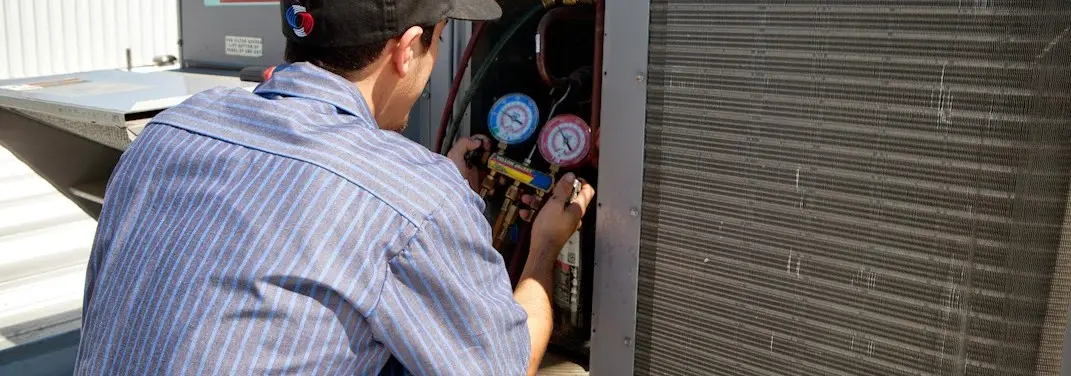 HVAC technician servicing a condenser unit in Palmetto Bay