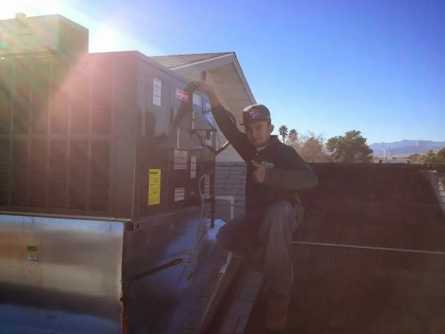 HVAC technician performing AC Tune-Up on a rooftop unit in Palmetto Bay